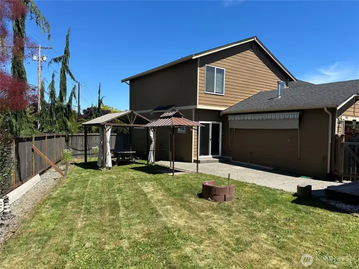 Large backyard with hardtop gazebo, retractable sunshade and firepit. Large backyard with hardtop gazebo, retractable sunshade and firepit.