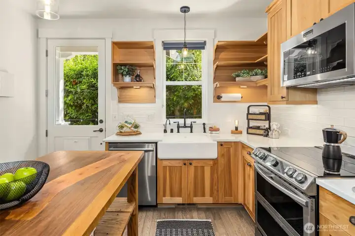 Subway tile, apron sink, under-cabinet lighting, and range with dual ovens are some of the features of this kitchen.