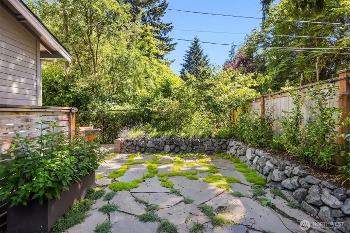 Here is the flagstone lined area which will look even better as the moss really starts growing. On the other side of the fence to the right is the community off-leash dog run. This home has direct access to it.