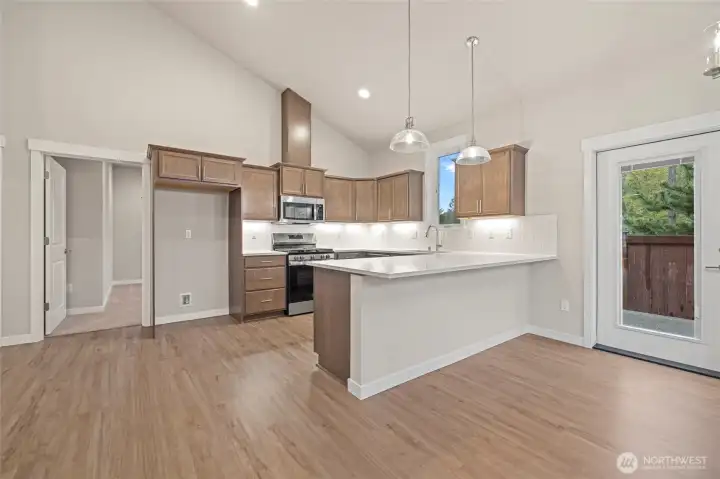 The kitchen has a gas range, dw, micro hood and quartz counters.