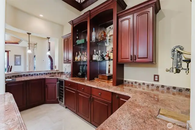 The double-sided bar features a genuine copper sink. There is also a beverage fridge and plenty of storage. Located near the kitchen and dining area, it could easily sit 6-8 people. The perfect spot for gathering and entertaining!