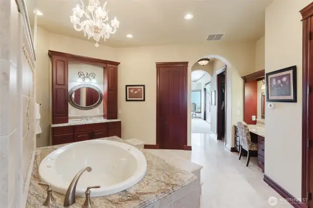 Beautiful spa-like primary bath with walk-through shower that has double body sprays on each side. In front of the shower is the large jetted tub with walk-up stairs. There are 2 separate sinks and vanities, as well as a seated makeup vanity. Private toilet and bidet. His and Hers closets on each side as you walk through the primary bath to the bedroom.
