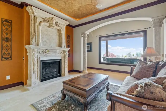 The living room has a 10ft. high sculptured marble fireplace and a lovely view of the pool and pool deck. This room includes stunning lighted soffit faux painted ceilings.