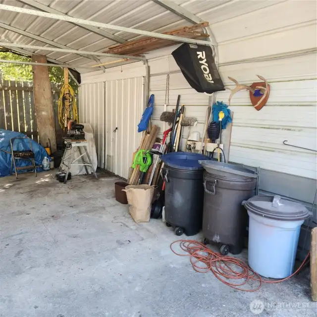 Far end of large carport showing dbl lockable door for  hardware storage