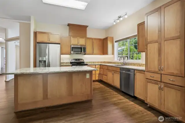 Updated kitchen with quartz, center island eating bar and stainless appliance package, opens to family room, eating area and dining room