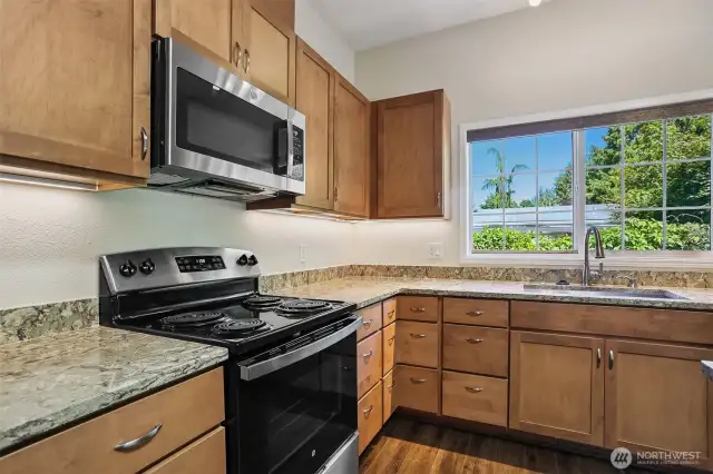 Updated kitchen with quartz, center island eating bar and stainless appliance package, opens to family room, eating area and dining room