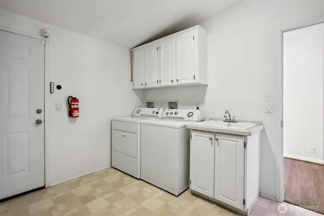 Laundry room with full size washer and dryer, utility sink and access to the attached 2 car oversized garage and workshop.