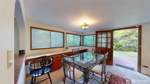 Dining area surrounded by windows, offering peaceful views of the natural landscape.
