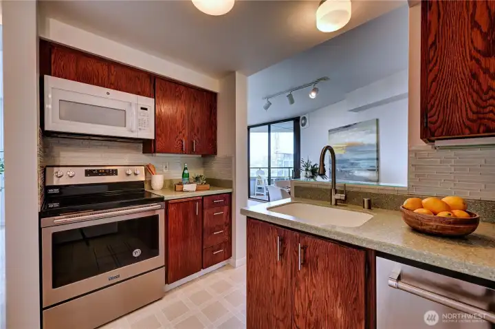 Nicely updated kitchen with oak cabinetry, lovely countertops & beautiful glass tile backsplash.