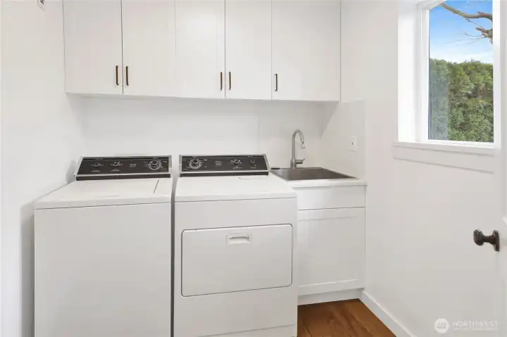 Conveniently situated between the garage and kitchen, the laundry room features a handy sink and extra storage, making chores feel a little less like work.