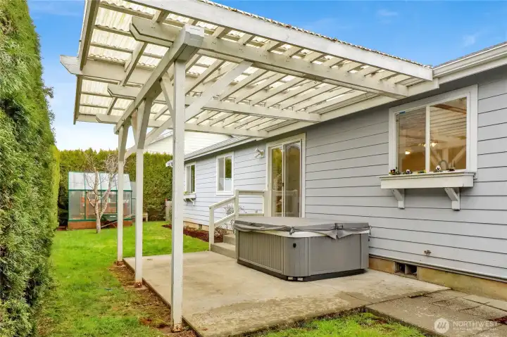 The backyard features a covered pergola, offering shelter for outdoor dining, relaxing, or enjoying the fresh air rain or shine.