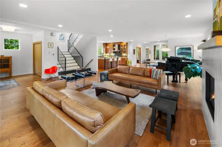 looking toward the open dining area and kitchen, this view shows the full depth of the main floor's open-concept layout. The staircase to the upper level and the front entry door are visible in the background.