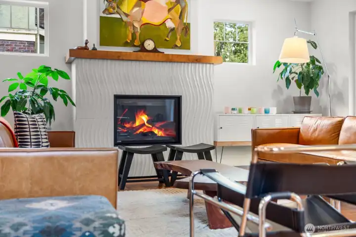 The sculptural wave-tile fireplace with wood mantel is the heart of the living room — a striking focal point that's as functional as it is beautiful.