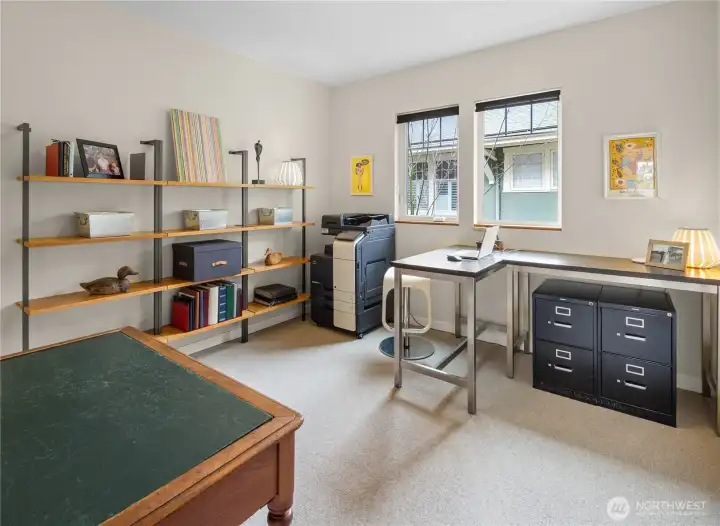 An upper-floor room set up as a home office. The room's size make it suitable as a fourth bedroom or dedicated workspace.