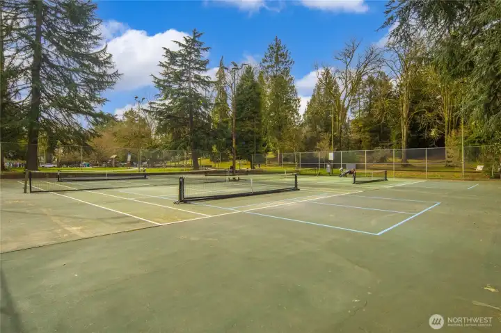 The park's four lighted courts are lined for both tennis and pickleball, free to reserve and open daily — all just a short stroll from home.