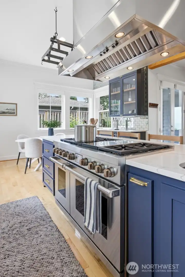 Center island with Wolf double oven range, with wet bar in the back corner.