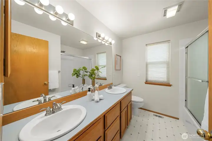 Full bathroom with double vanity on upper lever.