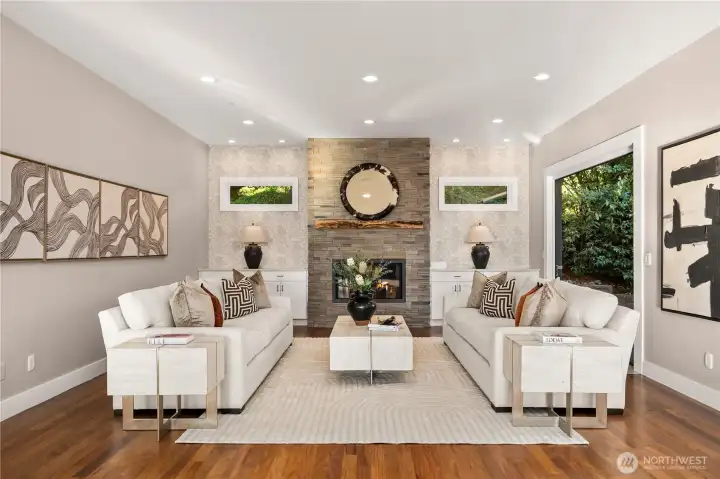 A spacious yet inviting living room centers around a stunning floor-to-ceiling stone fireplace, creating a warm and elegant gathering space for everyday living and effortless entertaining.