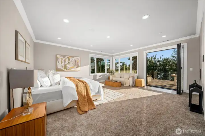 A spectacular primary retreat featuring a private sitting area, expansive view windows, and direct access to a private terrace through Cantina folding doors