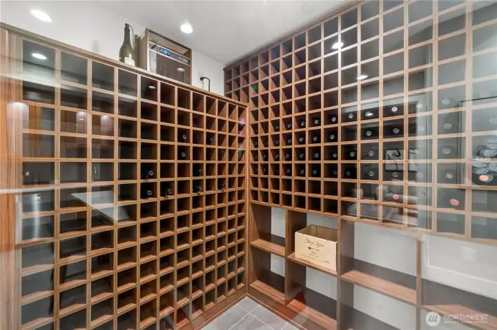 Temperature-controlled wine room with custom floor-to-ceiling walnut racking, offering elegant display and storage for an extensive wine collection