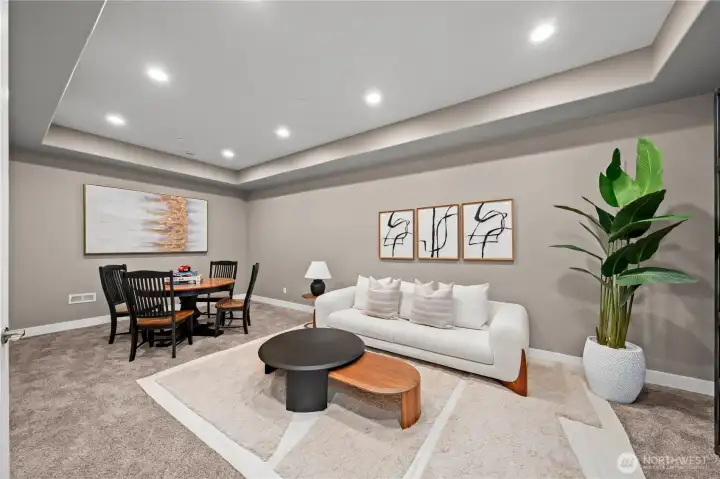 Expansive lower-level bonus room designed for entertaining, featuring generous gathering spaces that seamlessly connect to the private theater, temperature-controlled wine room, kitchenette, and guest suite.