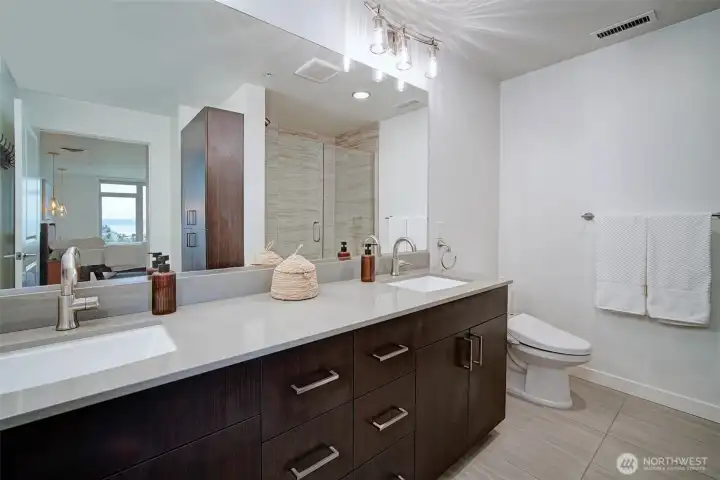 Primary bathroom with double vanity and toilet with bidet system.