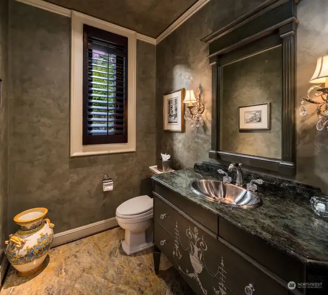 The main level features two powder rooms, including a formal Powder Room personalized with Marble Custom Vanity, Venetian Plaster finish, and Crystal Accent Hardware.