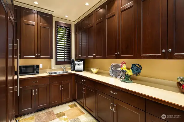 A generous second kitchen, adjacent to the Chef’s Kitchen, with custom walnut cabinetry, second prep sink and 36 inch Sub-zero Refrigerator/Freezer.