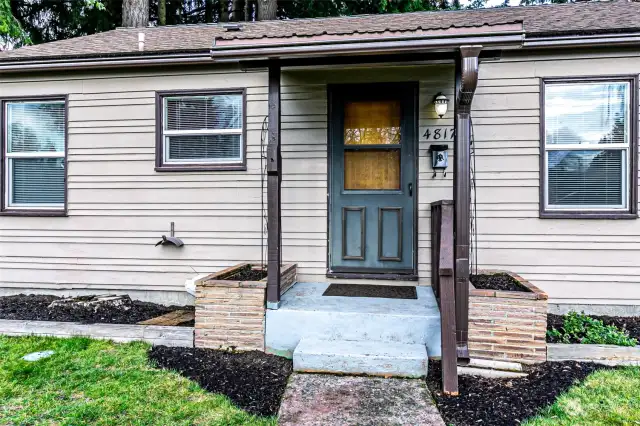 Covered front porch with brick planters.