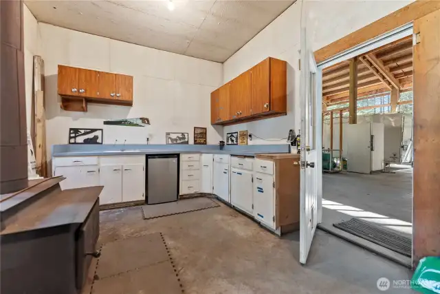 Main floor has a big shop space with lots of counters and cupboards. Wood stove for heat, its own propane tank and big compressor. Plus ventilation.