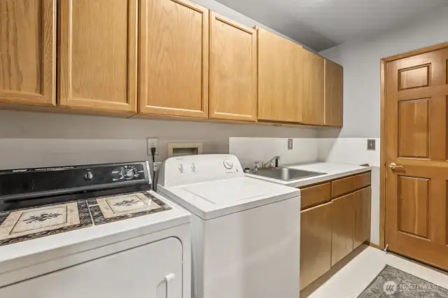 Spacious and functional laundry/mud room featuring a sink and abundant cabinet and storage space.
