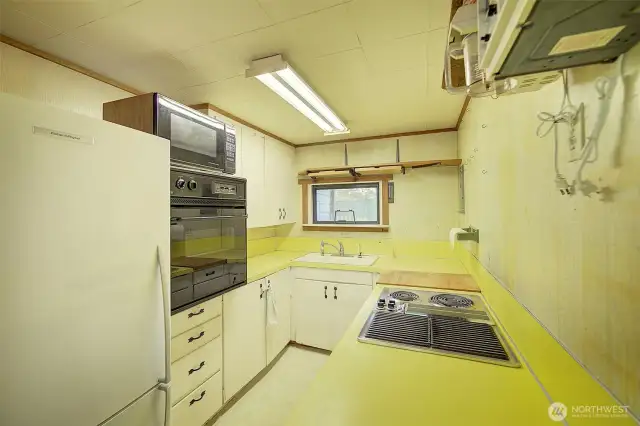A galley style kitchen is featured in the house