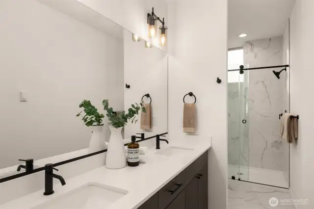 Ensuite bath includes a double sink vanity with a ceramic tile walk-in shower.