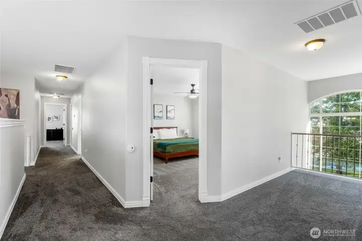 View of the hall upstairs with the door to the right is a bedroom and then a room at the end of the hall. To the right overlooks the entry and out to the front yard