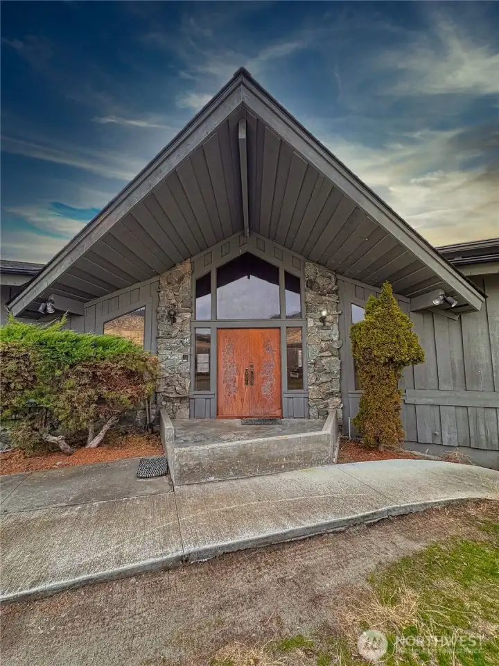A striking exterior entry welcomes you with beautifully etched wooden double doors, offering a warm, elegant first impression and a sense of craftsmanship from the moment you arrive