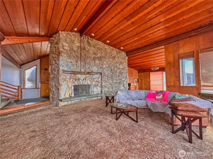 Soaring ceilings and statement rock fireplace in living room provides timeless elegance