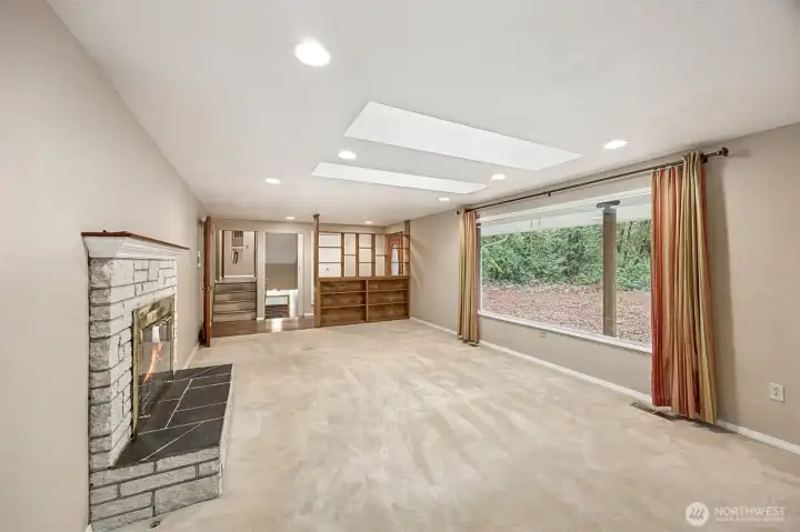 Cozy gas fireplace and built-in shelving create a warm gathering space.