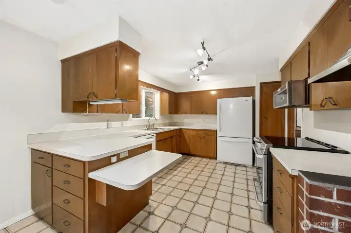 A welcoming kitchen layout with great prep and storage space. (Newer range/induction stove & microwave)