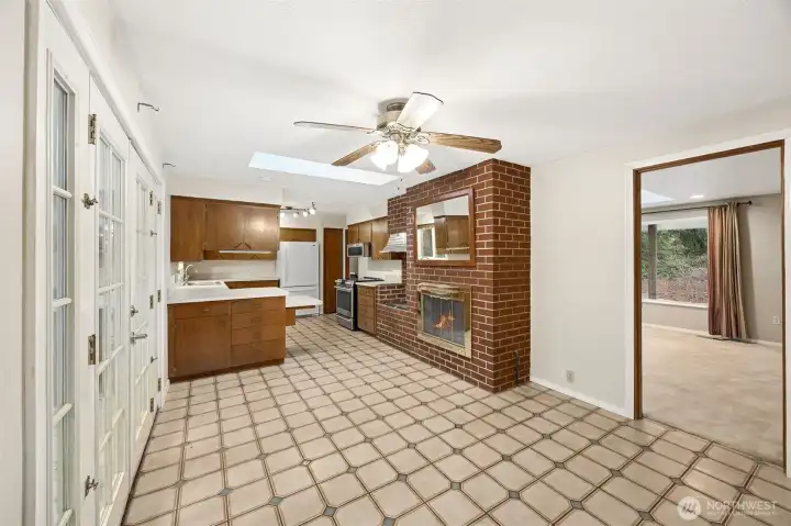 Kitchen opens comfortably to the dining area for easy flow. Dual-sided gas fireplace shared between rooms.
