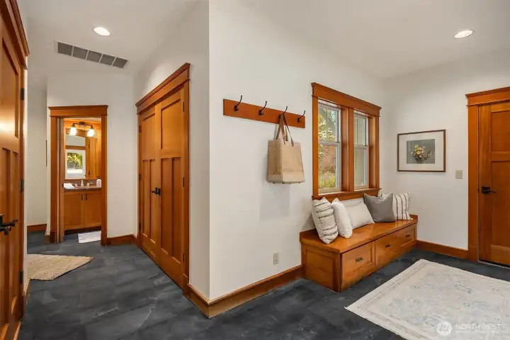 Just inside the garage entry is the generous mudroom that serves as a drop zone for coats, shoes, and everyday gear. It includes an attached half-bath and the utility closet, all connected to the kitchen for a functional flow.