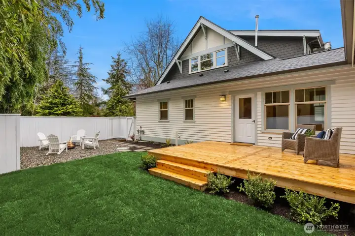 The rear yard is fully fenced, offering privacy and a secure space for outdoor living and play. It features a generous new cedar deck along with a well-kept lawn and a versatile gravel area ideal for additional seating, a fire pit, or low-maintenance landscaping.