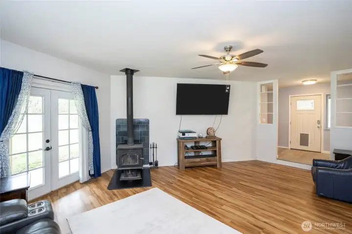 Comfortable living area featuring a wood stove for cozy days and French doors leading to the beautiful outdoor space.