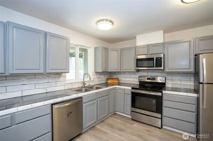 Stainless steel appliances enhance the kitchen with a clean, modern finish.