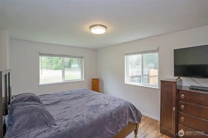 Primary suite with large windows that fill the space with natural light.