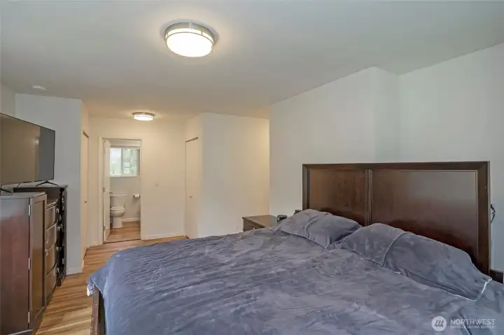 Bright and inviting primary suite featuring dual closets and a private full bath, creating a comfortable retreat.