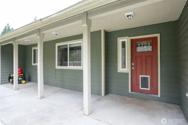 Front entry with a spacious covered patio, offering a welcoming outdoor sitting area.