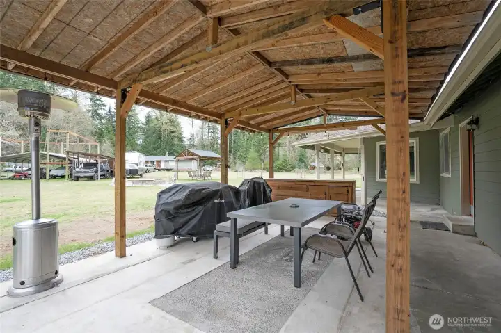 Step outside the utility room to a covered BBQ gazebo, with a cozy firepit just beyond for the perfect outdoor gathering space.