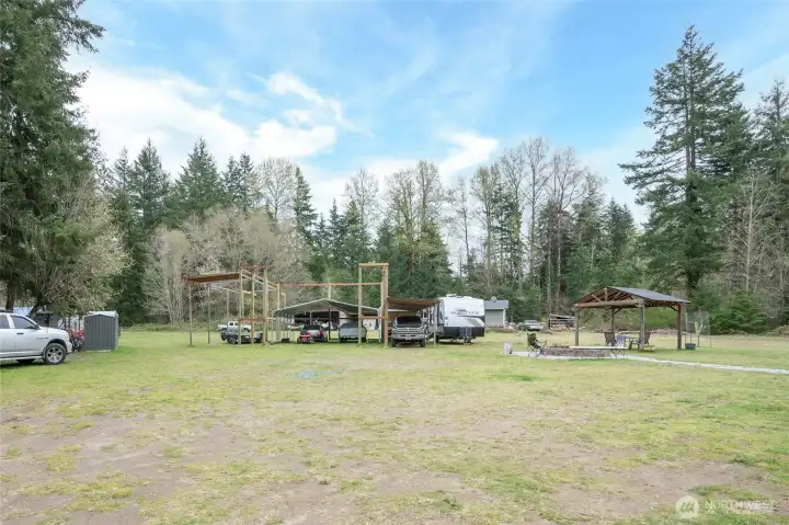 View of the large pole barn/shop, ready for completion, with a firepit and second gazebo just to the right.