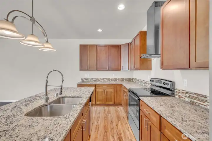 Island granite countertops and soft-close cabinets make this a pleasure to prepare meals.