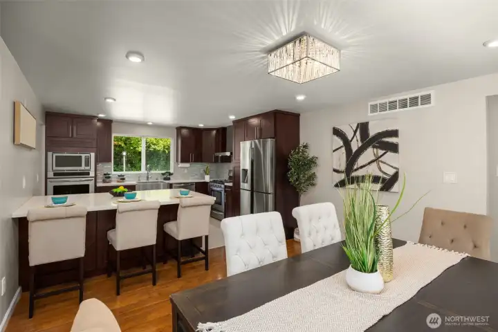 Remodeled kitchen with quartz countertops and backsplash, stainless steel appliances, double oven and eating nook